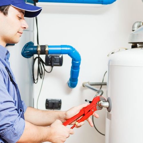 A Technician Works on a Water Heater.