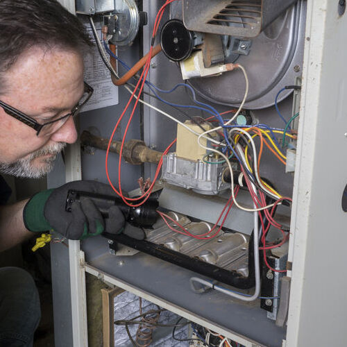 A Technician Repairs a Central Heating System.